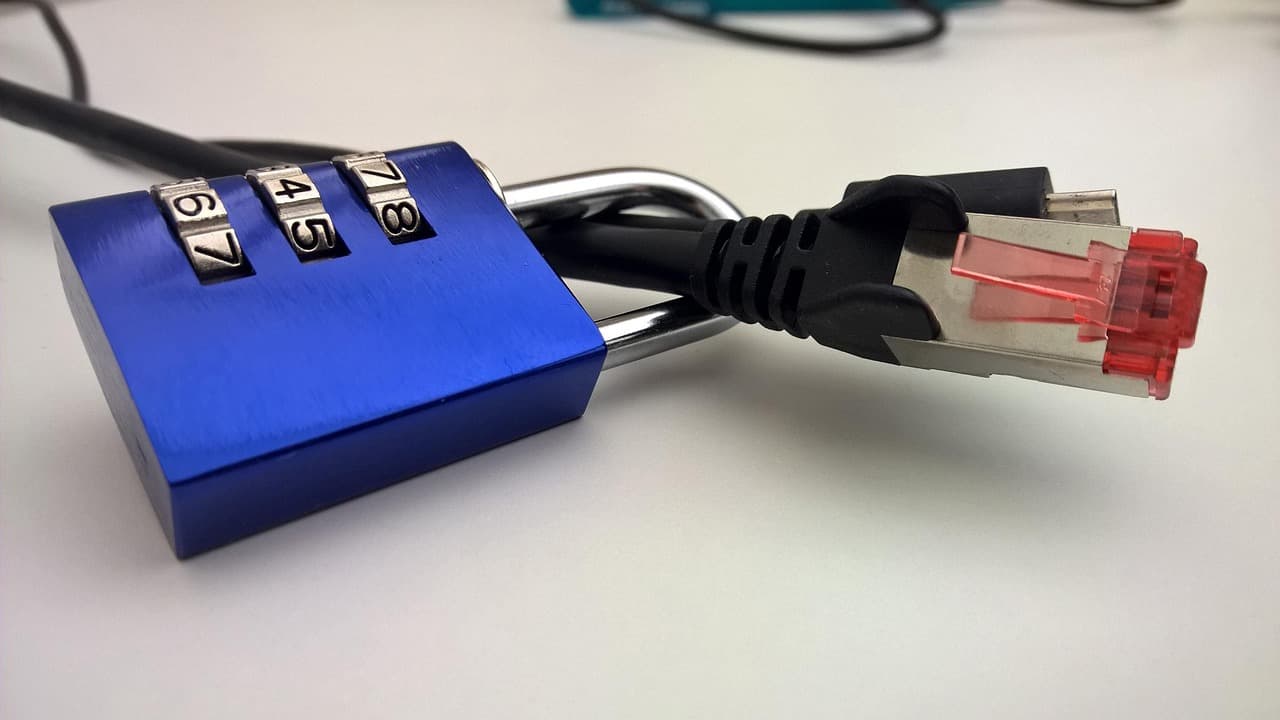 Un candado de combinación azul bloqueado alrededor de un cable de red Ethernet