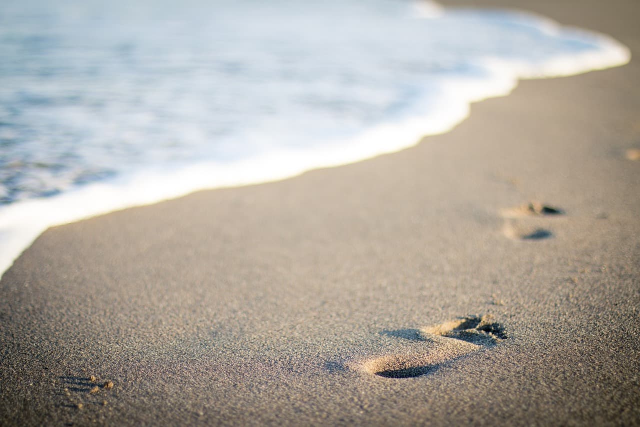 Une ligne d'empreintes de pas dans le sable, métaphore de la trace de données que vous laissez en ligne
