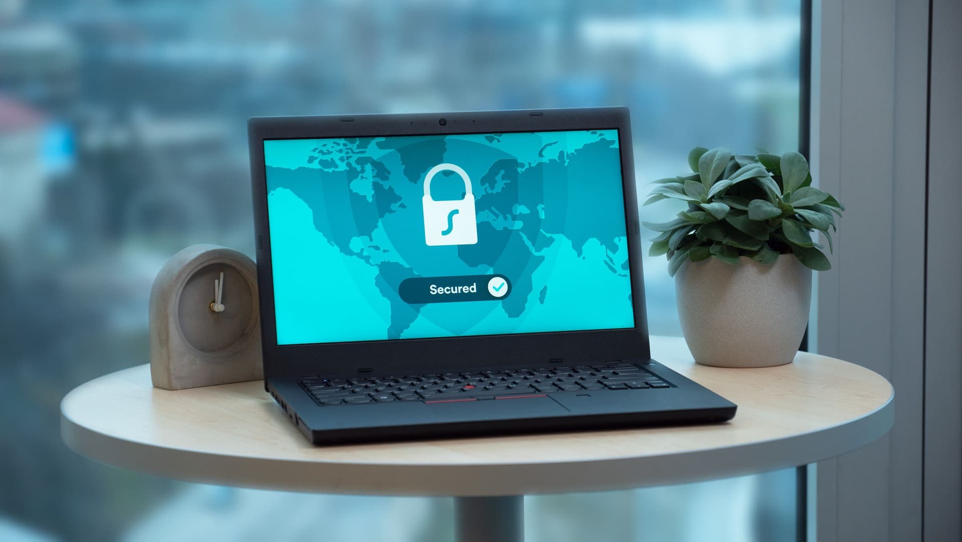 Un ordinateur portable sur une table affichant une icône de cadenas sur une carte du monde avec la mention « Secured » - une interface rassurante, mais la vraie question est de savoir qui détient les clés de chiffrement.